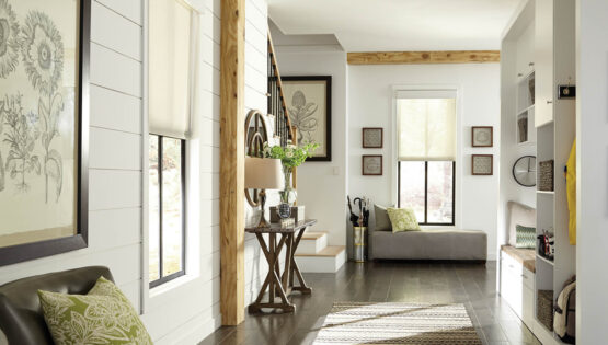 A home’s living area with Lutron motorized shades partially lowered and sunlight filtering through the windows.