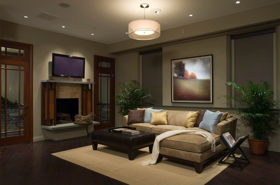 A living room with Lutron shades and lighting, in-ceiling speakers, and a TV above the fireplace.