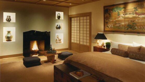 A bedroom with a large bed, a sliding silkscreen door, and recessed ceiling lights.