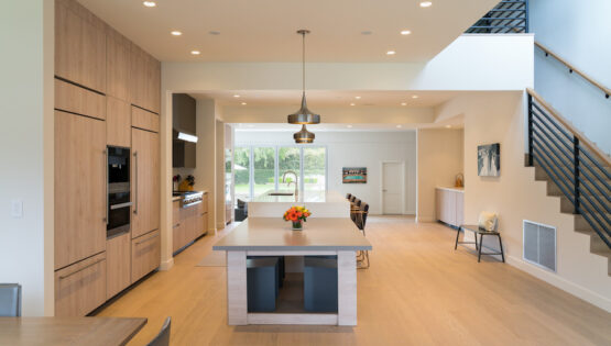 A kitchen space with a white island illuminated by warm white lights.