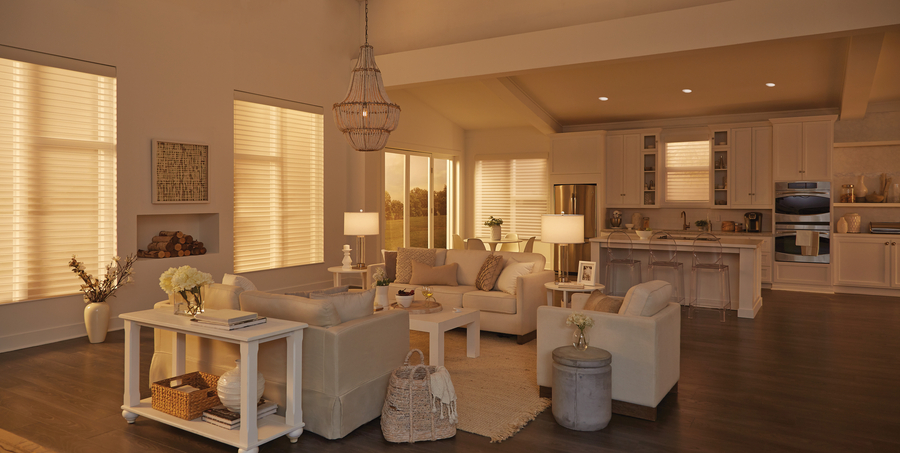 A great room is lit by afternoon sunlight filtered through lowered shades on the windows.
