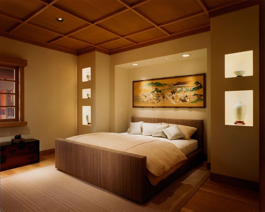 Warmly lit bedroom with recessed display lighting, wood accents, neutral bedding, and art above the bed for a tranquil feel.