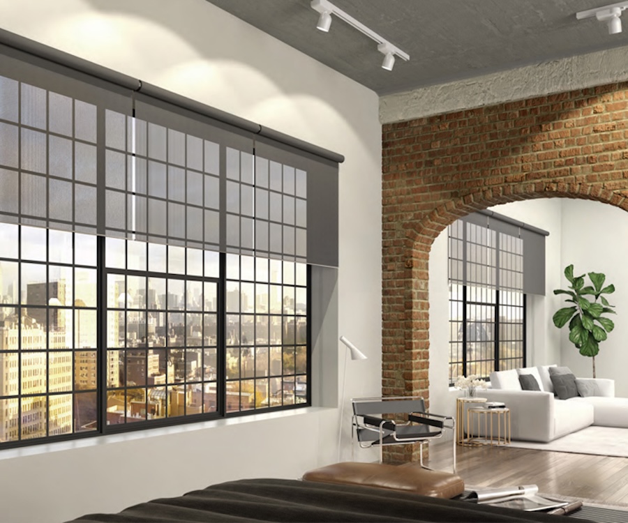 Lutron Palladiom motorized shades partially lowered on large floor-to-ceiling windows in a modern brick luxury loft.